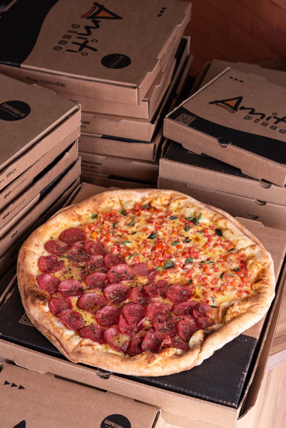 Pizza de calabresa sobre caixas de entrega